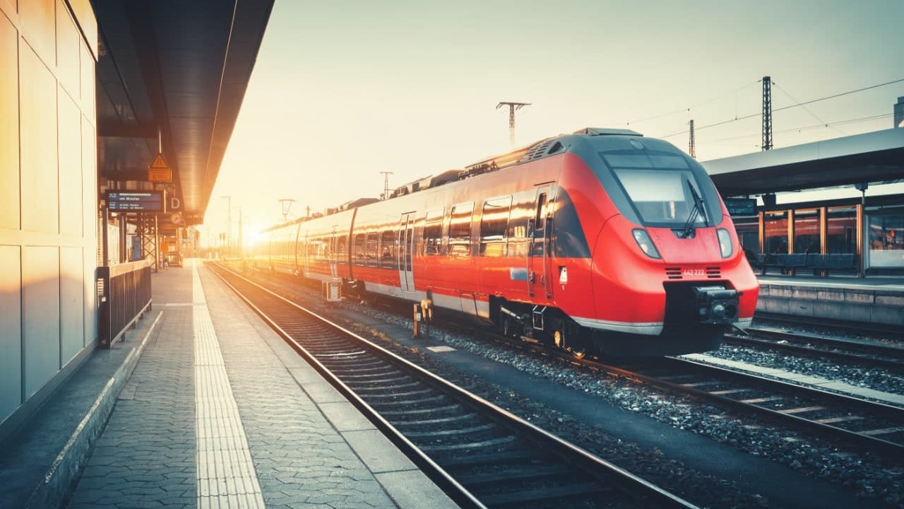 Red modern train at sunset station – Deutschlandticket for €63/month on all buses and trains across Germany
